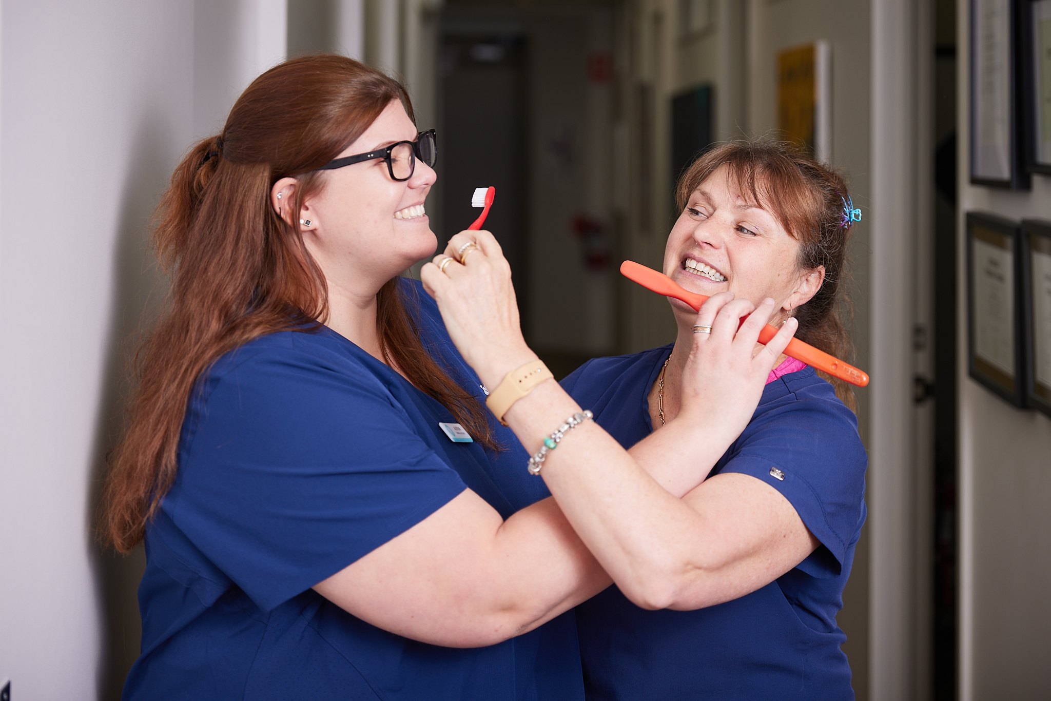 Two of our dental assistants joking around with a giant toothbrush